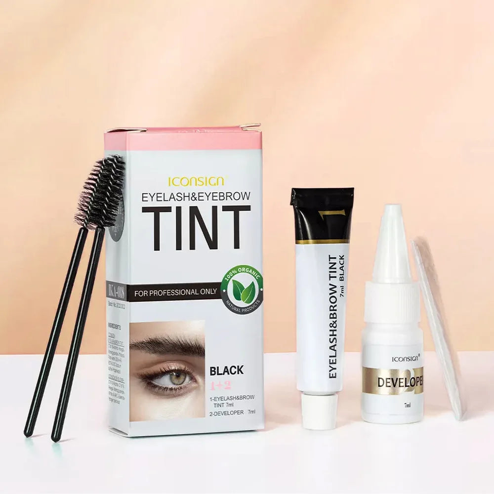 Eyelash and eyebrow tinting products including a box, brush, and developer on a light background