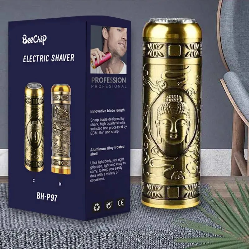 Gold electric shaver with Buddha design next to its packaging on a textured surface.